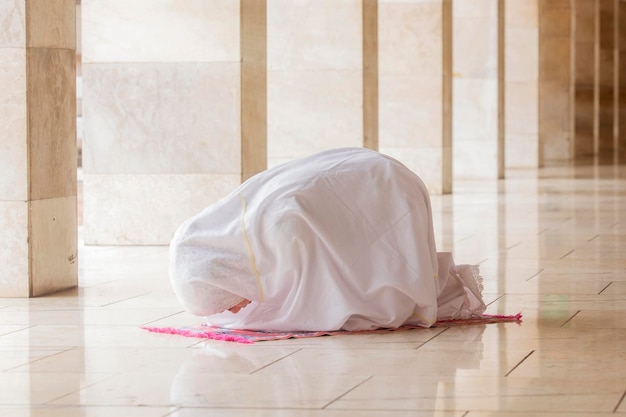 Mujer haciendo Salat con gesto postrado en mezquita