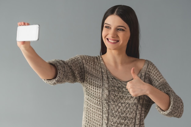 Foto mujer está haciendo selfie usando un teléfono inteligente