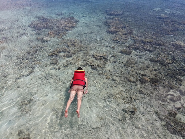 Foto una mujer está haciendo snorkel cerca de un arrecife de coral