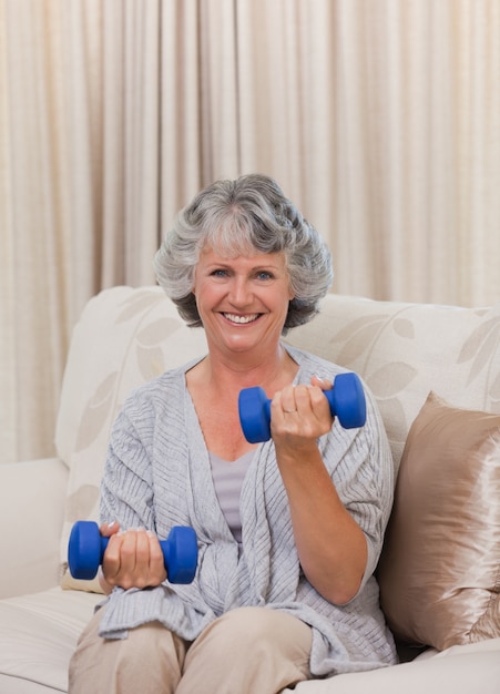 Mujer haciendo sus ejercicios en su sofá
