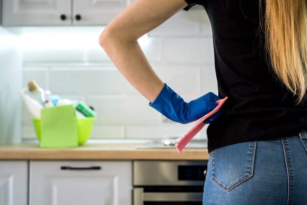 Mujer haciendo tareas de limpieza de cocina con guantes de goma y trapo. concepto de limpieza