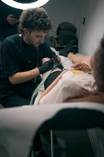 Mujer haciendo un tatuaje en la pierna