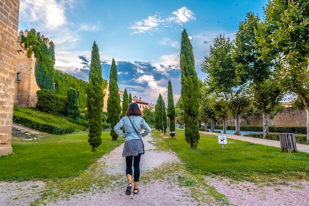 Mujer haciendo turismo rural en una ciudad medieval y su hermoso castillo