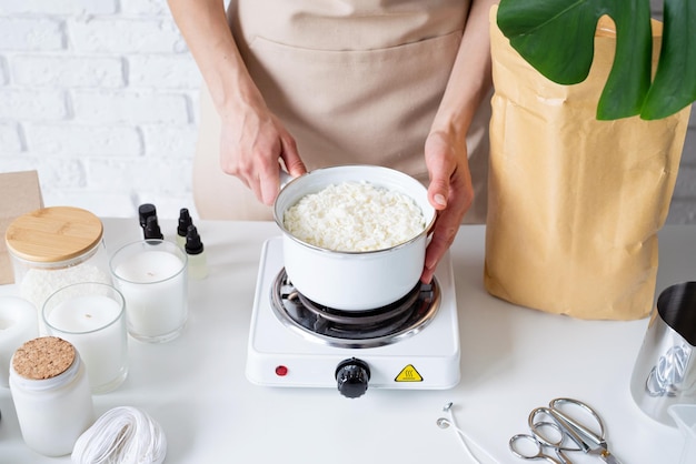 Mujer haciendo velas aromáticas decorativas con cera de soja