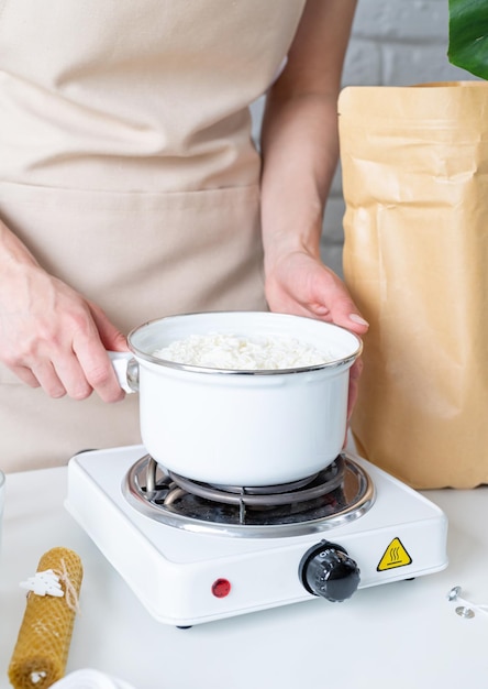 Mujer haciendo velas aromáticas decorativas con cera de soja