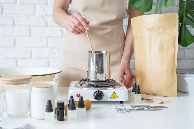 Mujer haciendo velas aromáticas decorativas en la mesa