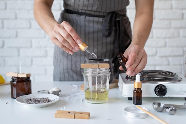 Mujer haciendo velas aromáticas decorativas en el primer plano de la mesa