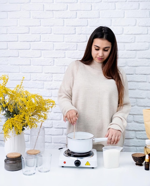 Mujer haciendo velas aromáticas decorativas en el primer plano de la mesa