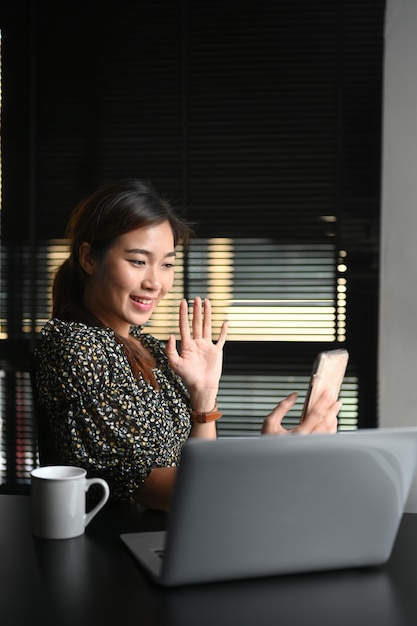 Mujer haciendo videollamada en la oficina