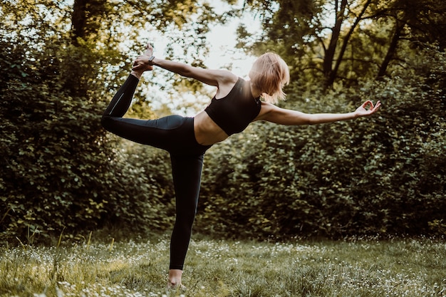 Foto mujer haciendo yoga al aire libre en medio de la naturaleza