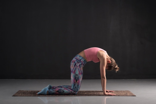 Mujer haciendo yoga asana simple posición de vaca o gato