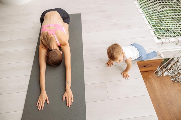 Mujer haciendo yoga mientras se estira en la habitación