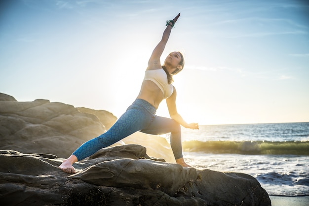 Mujer haciendo yoga en la playa