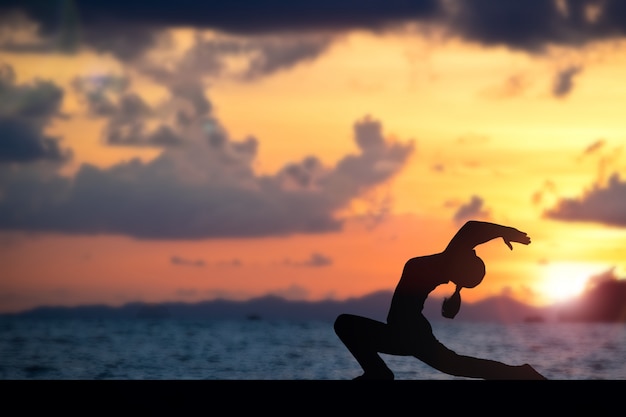 Mujer haciendo yoga en la playa