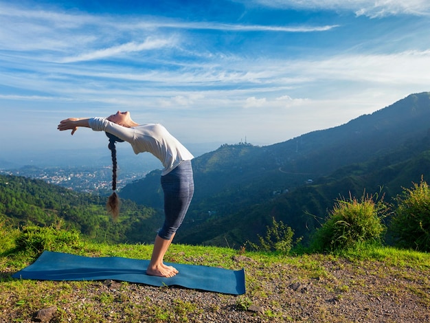 Mujer haciendo yoga saludo al sol Surya Namaskar