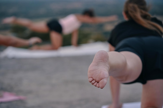 Una mujer haciendo yoga con vistas a las montañas de fondo.