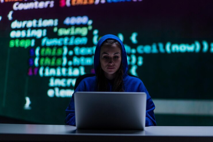 Foto mujer hacker anónima encapuchada por computadora en la habitación oscura por la noche concepto de ciberguerra