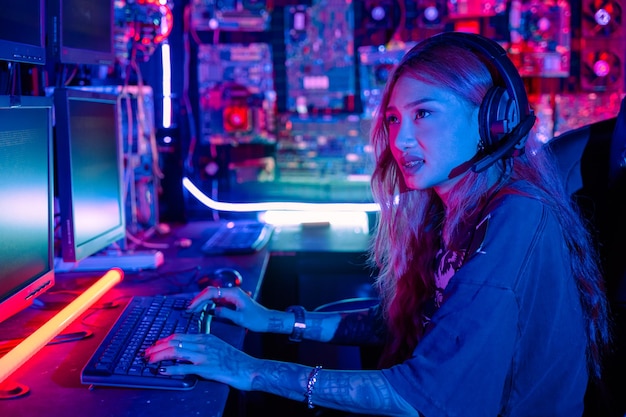 Una mujer hacker sentada frente a una computadora escribiendo en un teclado hackeando servidores a la luz del neón una mujer hacker irrumpe en un centro de datos una mujer gamer transmitiendo juegos en línea