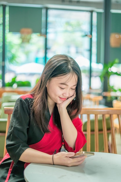 Mujer hermosa asiática joven que usa un teléfono inteligente para hacer compras en línea y transferir dinero