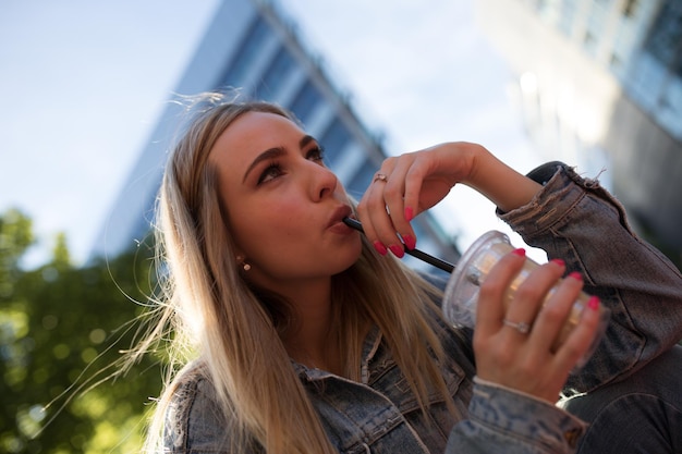 Foto mujer hermosa bebiendo café en la ciudad