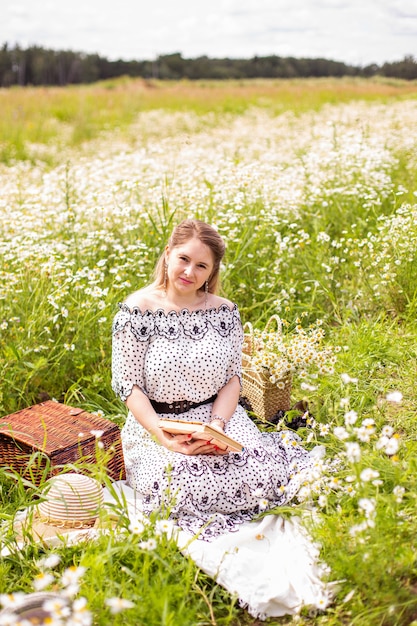 Mujer hermosa en el campo con flores. Foto de alta calidad