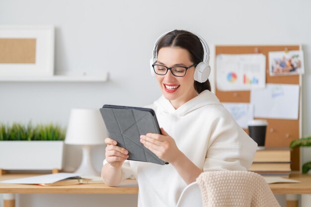 Mujer hermosa casual feliz que trabaja en la oficina en casa.