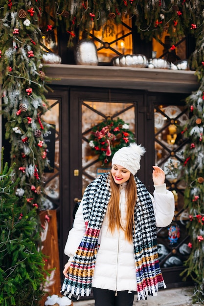 Mujer hermosa en una chaqueta de invierno celebrando la Navidad