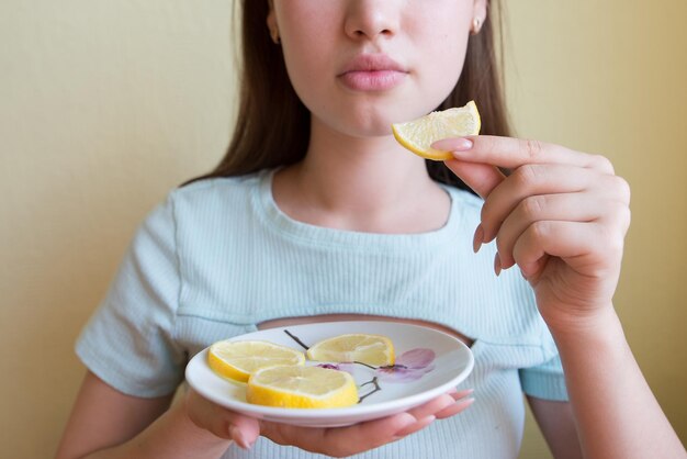 Mujer hermosa comiendo limón de cerca