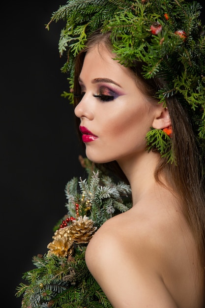 Mujer hermosa en una corona de Navidad