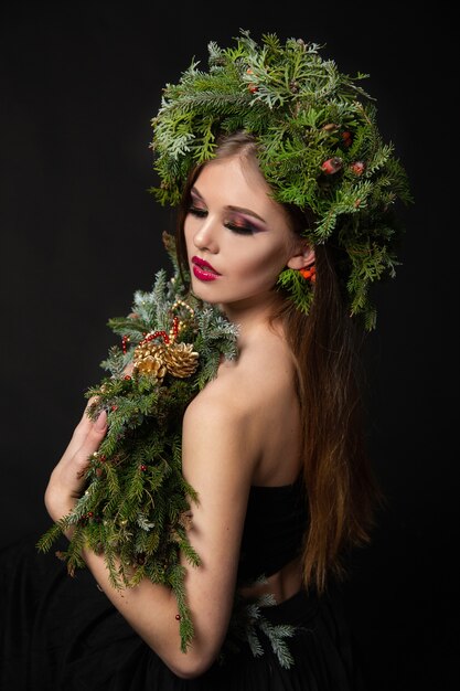 Mujer hermosa en una corona de Navidad