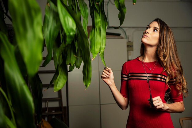 Foto mujer hermosa cortando plantas