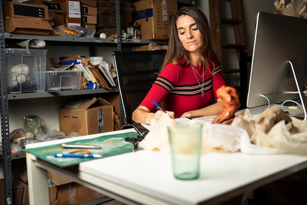 Foto mujer hermosa escribiendo mientras usa la computadora en casa