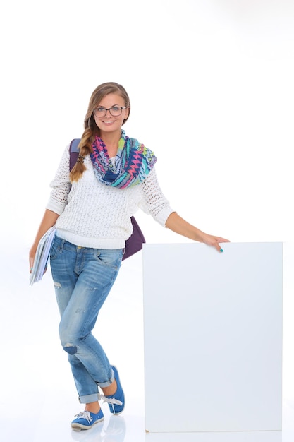 Mujer hermosa estudiante señalando en el tablero en blanco