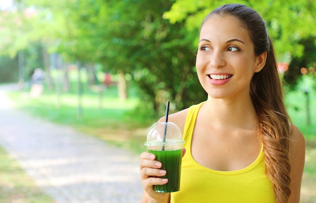 Mujer hermosa feliz con batido verde