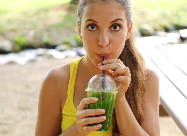 Foto mujer hermosa feliz con batido verde