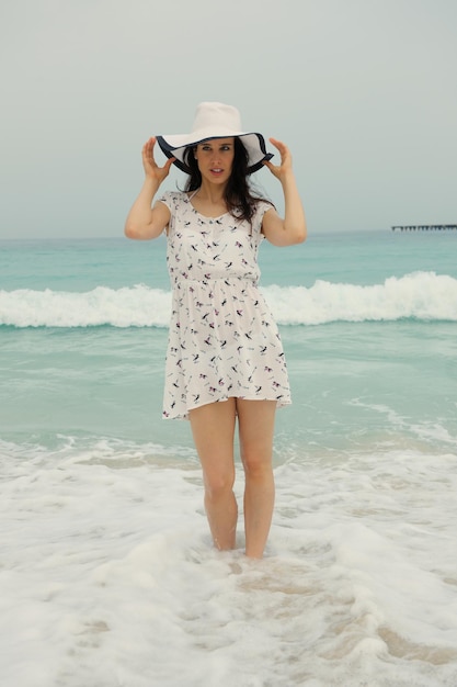 Mujer hermosa feliz disfrutando de las vacaciones de verano en la playa