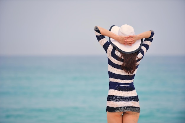 Mujer hermosa feliz disfrutando de las vacaciones de verano en la playa