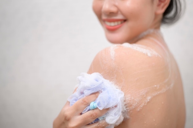 La mujer hermosa feliz se está duchando