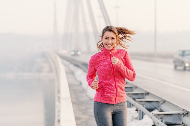 Mujer hermosa fitness disfrutando en la mañana de invierno. Concepto de fitness de invierno