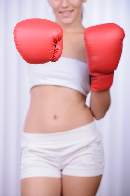 Mujer hermosa con los guantes de boxeo rojos.