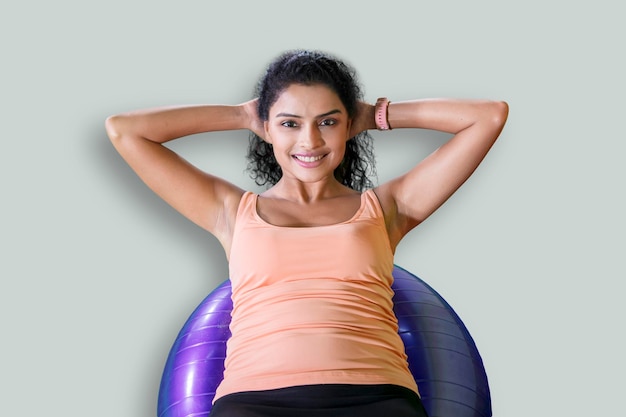 Foto mujer hermosa hace ejercicios con una pelota de fitness