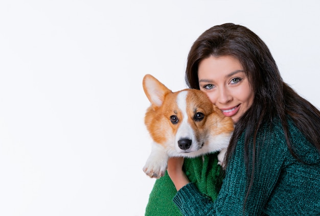 Mujer hermosa joven abrazando corgi perro