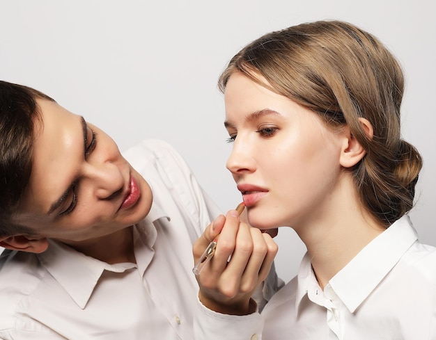 Mujer hermosa joven aplicar maquillaje por artista de maquillaje