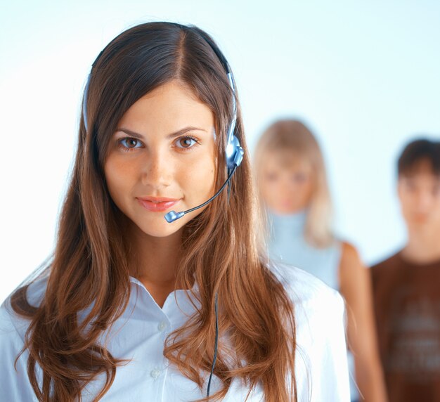 Mujer hermosa joven con auriculares con algunas personas en el fondo