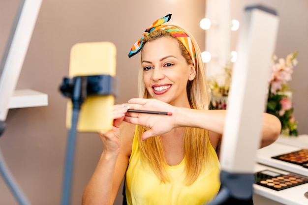 Mujer hermosa joven y belleza profesional componen artista vlogger o blogger grabando un tutorial de maquillaje para compartir en el sitio web o las redes sociales.