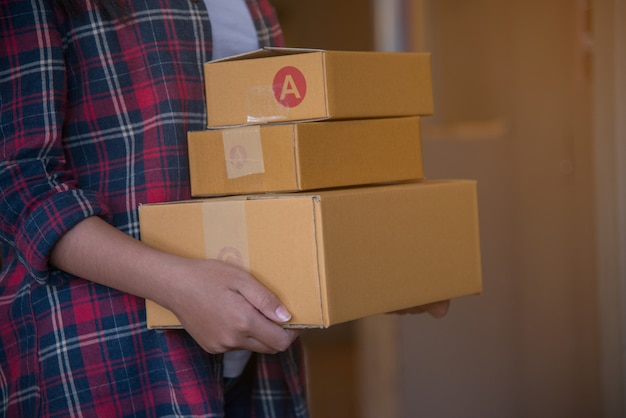 Mujer hermosa joven con la caja de regalo del asimiento en manos