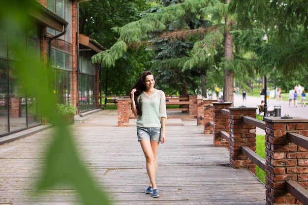 Mujer hermosa joven caminando en el parque