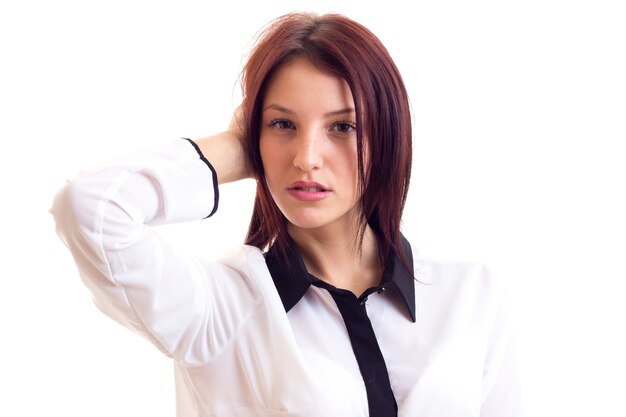 Mujer hermosa joven en camisa blanca y negra con cabello oscuro sobre fondo blanco en estudio