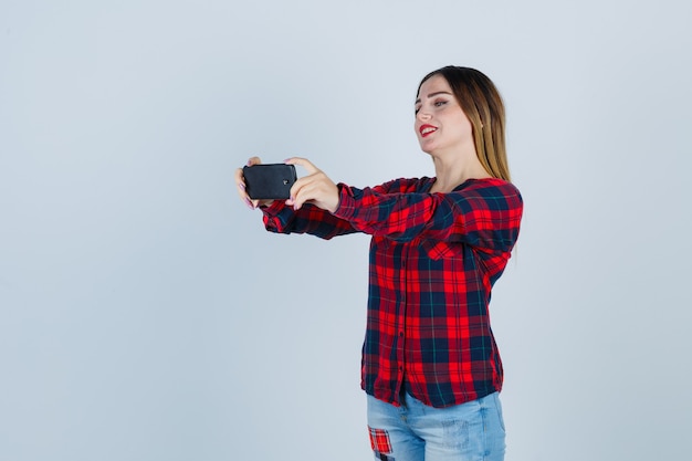 Mujer hermosa joven en camisa casual tomando selfie