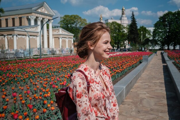 Mujer hermosa joven en campo de tulipanes Concepto de moda de primavera Naturalidad con estilo un paseo por el parque La idea y el concepto de mujeres felices en el Día Internacional de la Mujer